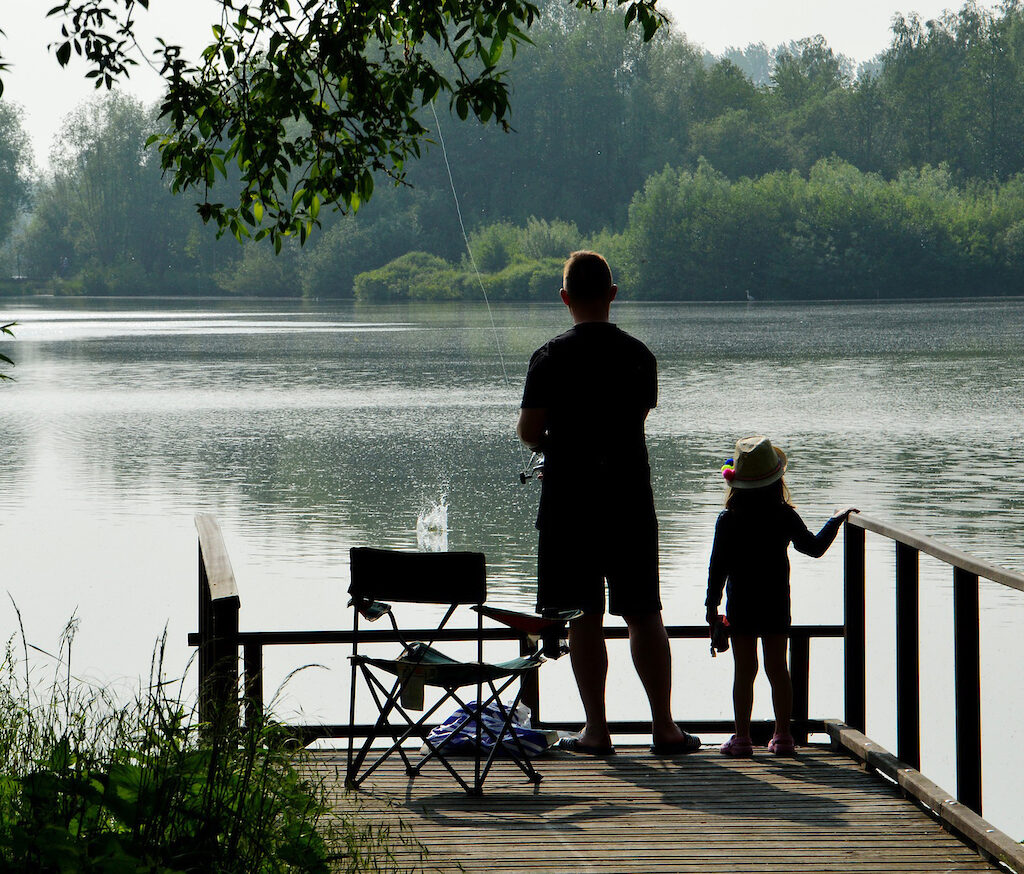 Parent and child fishing on a dock
