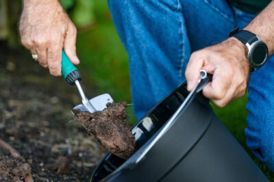 Man shoveling soil into bucket