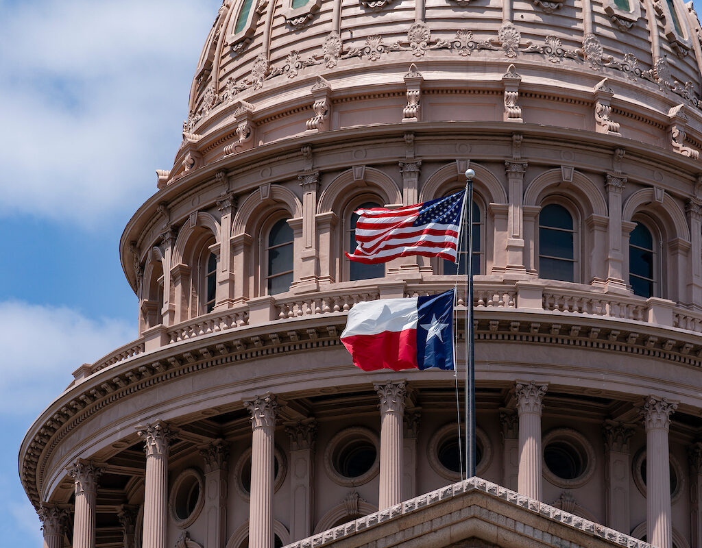 Flags flying in front of Texas Capitol building