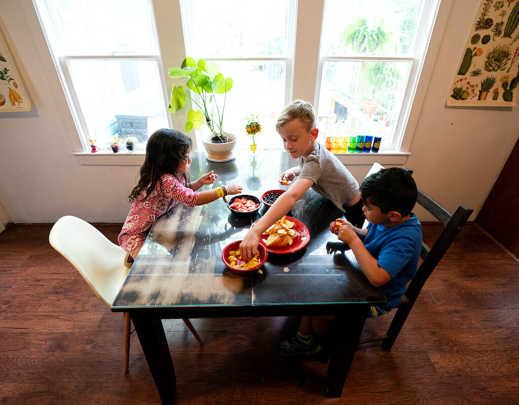 Children eating fruit at a table