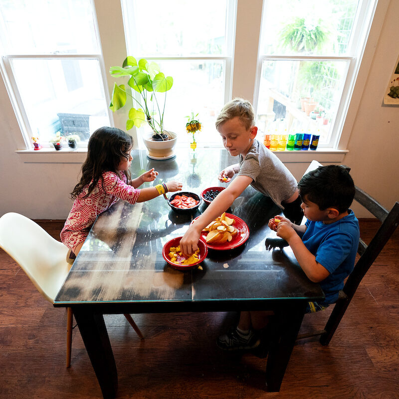Children eating fruit at a table