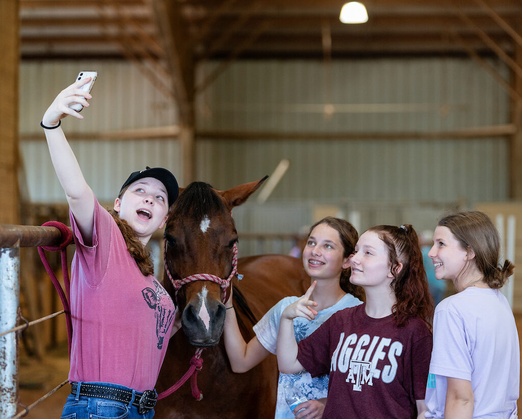 Teens taking a selfie with a horse