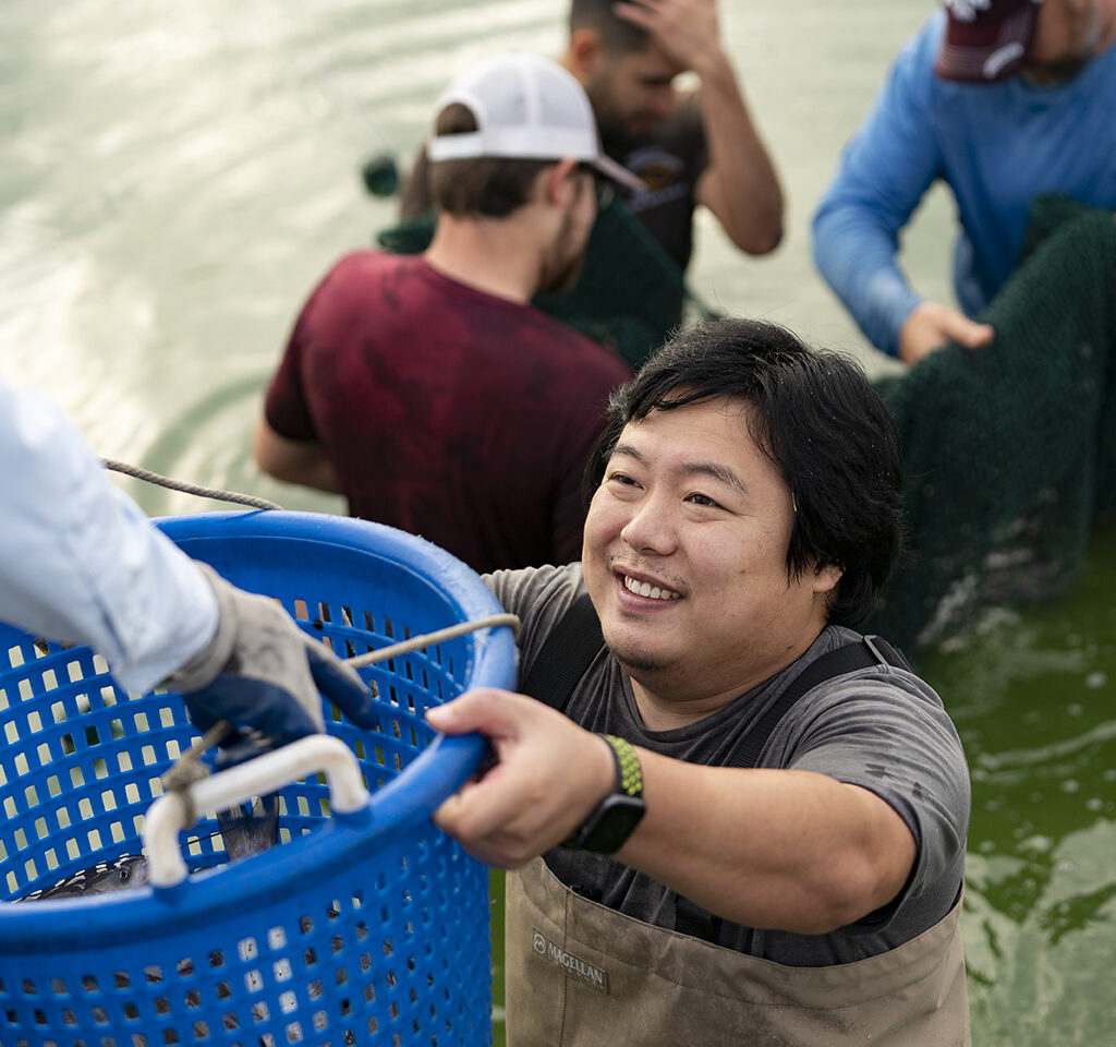 Man holding bucket with catfish in it