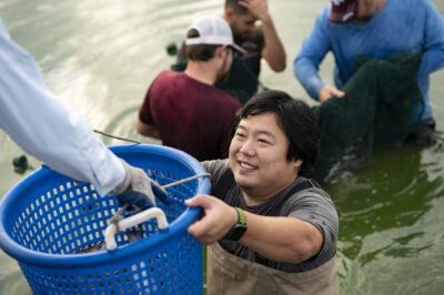 Man holding bucket with catfish in it