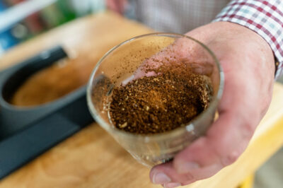 hand holding a glass with ground coffee