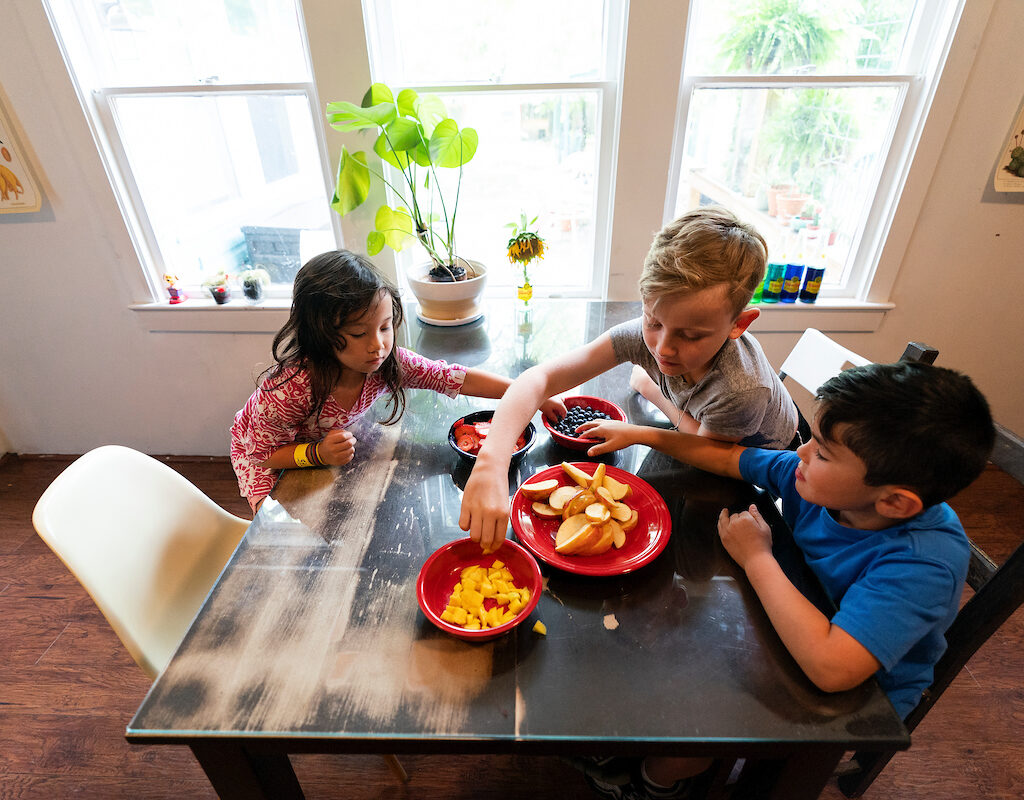 Children sharing bowls of fruit