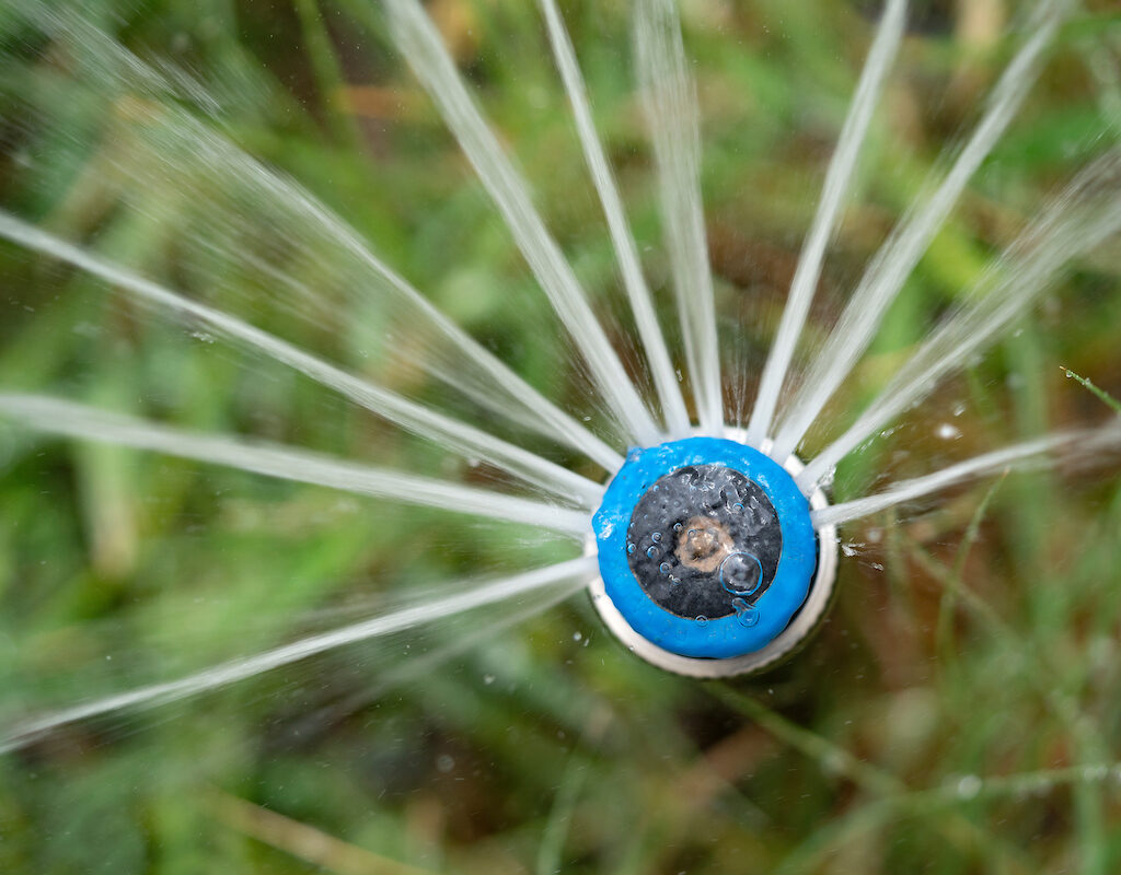 Close-up of a sprinkler head spraying water
