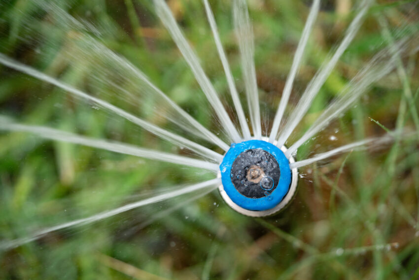 Close-up of a sprinkler head spraying water