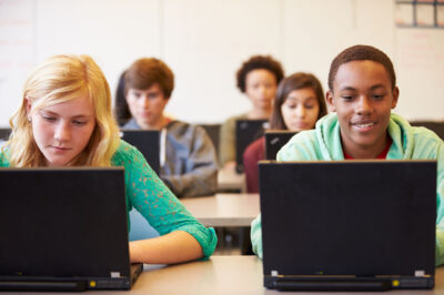 Students looking at laptops in class