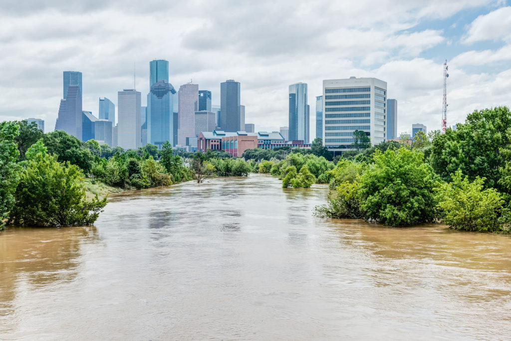 A flooded river with Houston skyline in the background