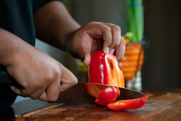 hands chopping a red pepper