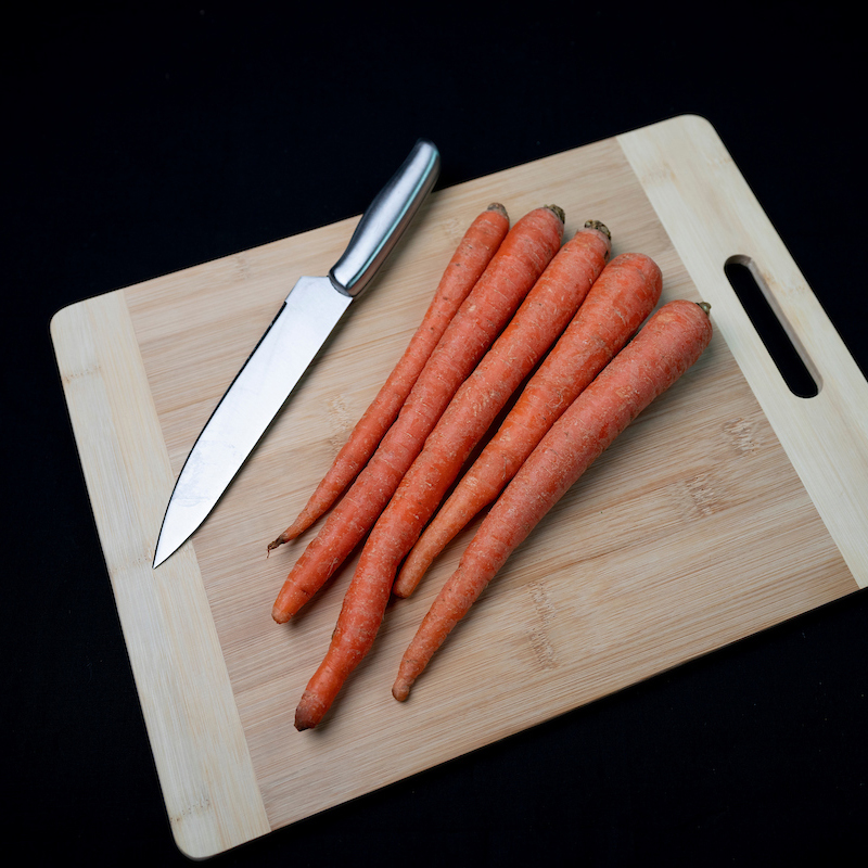 five carrots on cutting board