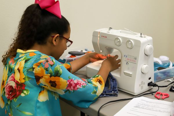 girl using sewing machine
